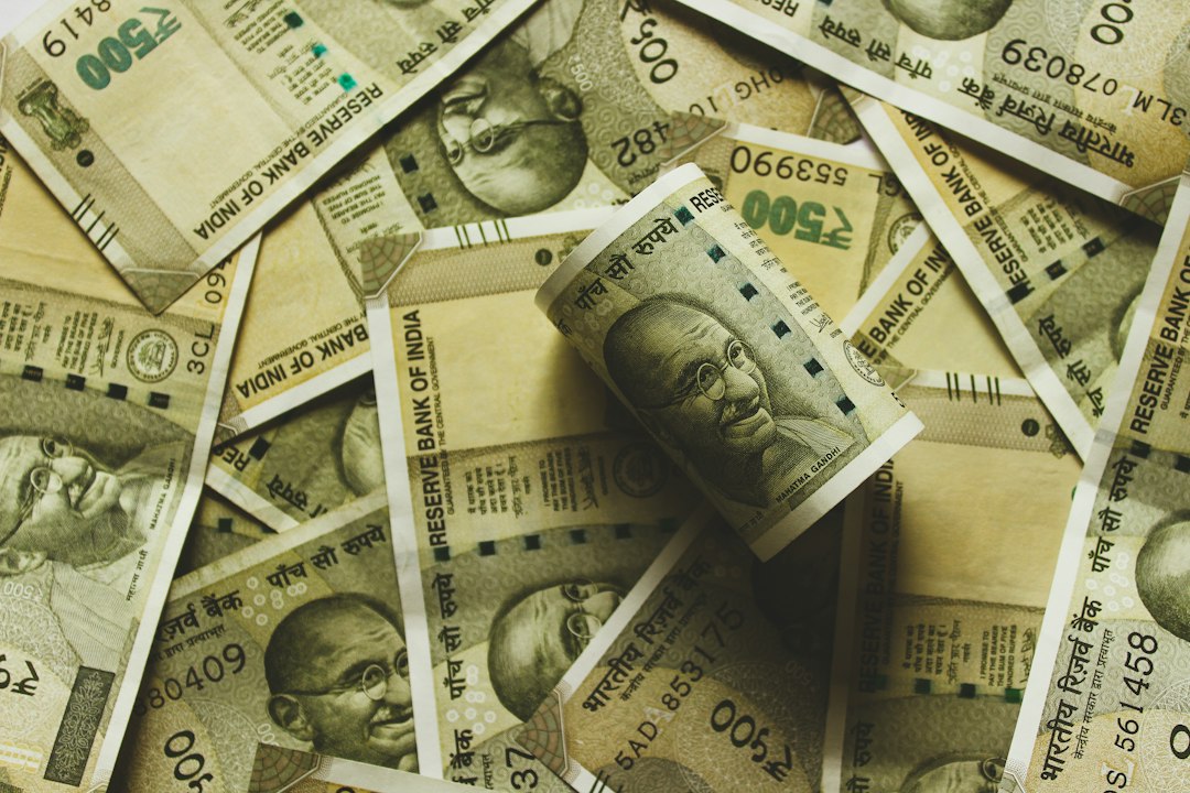 Indian rupee banknotes beside stock exchange documents