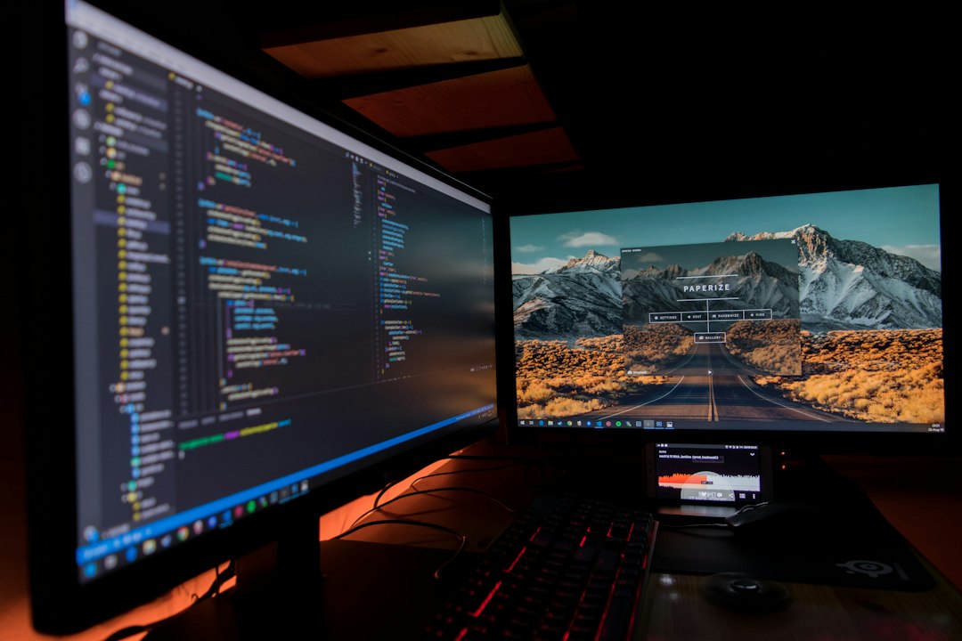 Code editor and stock chart on computer monitors