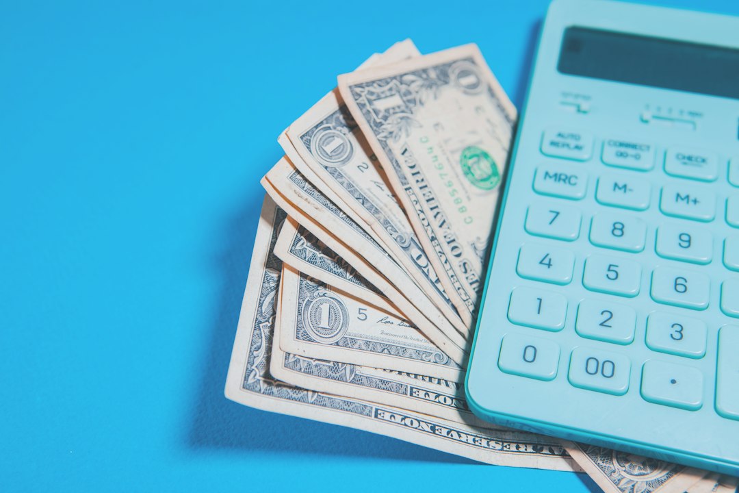 US dollar bills beside a household budget calculator
